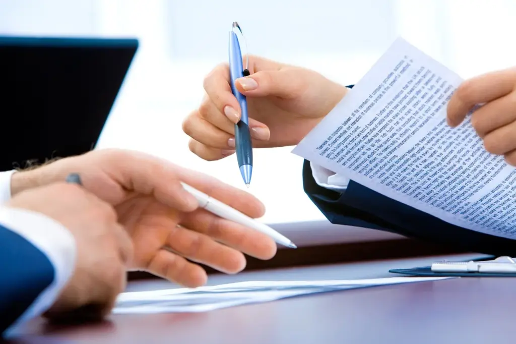 Stack of paperwork and a pen on a desk, illustrating the process of filing an Arizona workers' compensation claim