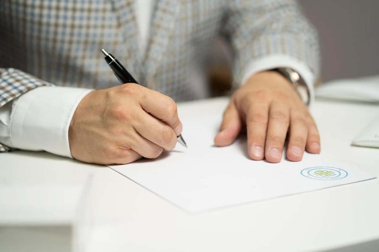 Couple signing divorce papers at a table with a lawyer