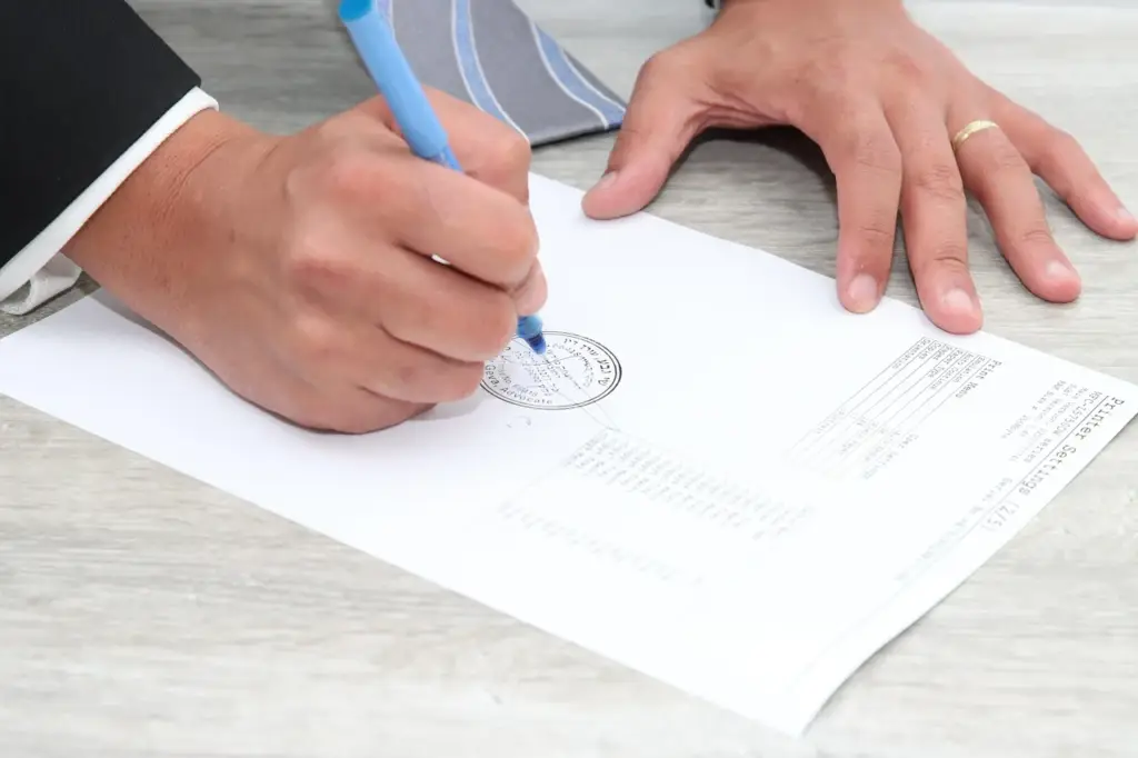 Hands signing an estate planning document