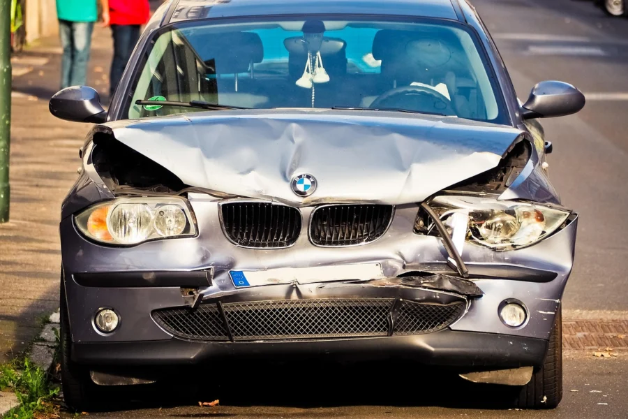 Hands holding settlement documents and pen over car accident forms