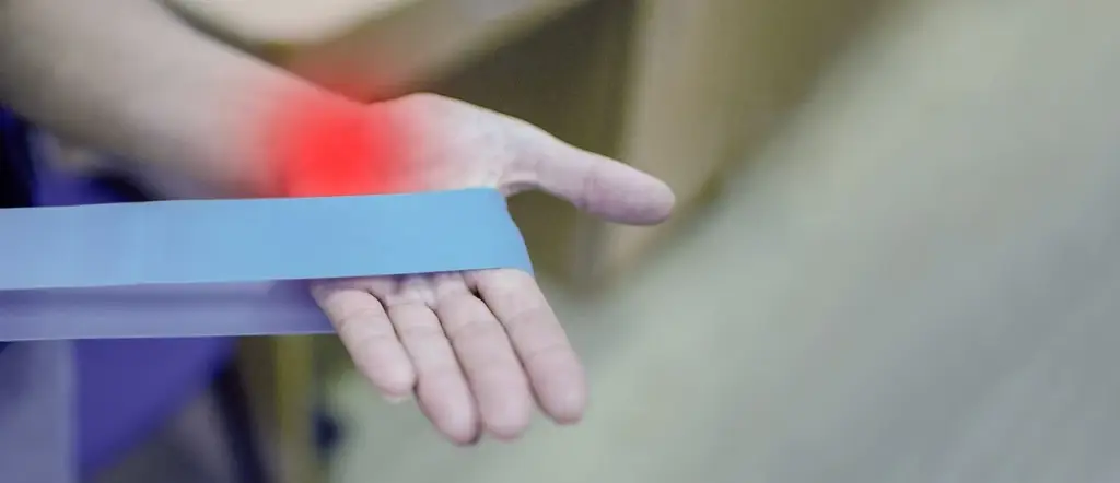 Office worker rubbing wrist showing repetitive strain from typing